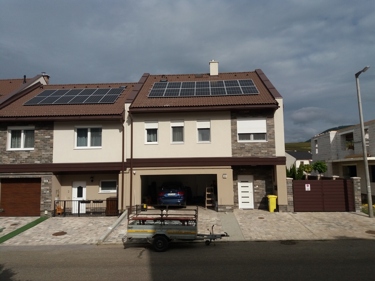 Modern családi ház tetőn napelem rendszerekkel.